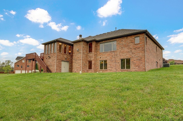 back of property with stairway, brick siding, and a lawn