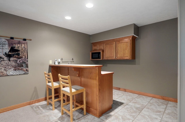 bar featuring black microwave, baseboards, and recessed lighting