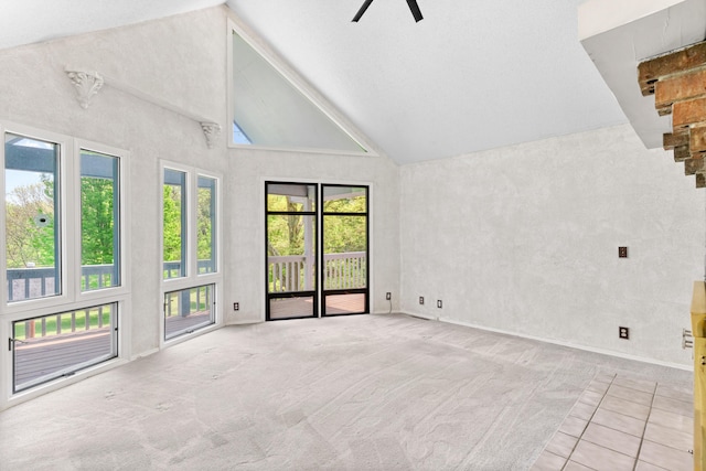 carpeted spare room with a ceiling fan, high vaulted ceiling, and baseboards