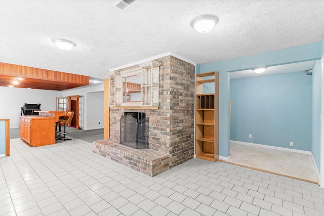 living room with baseboards, a textured ceiling, and a brick fireplace