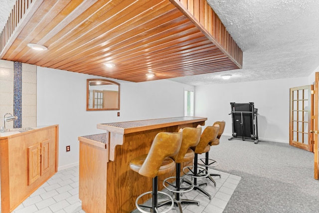 bar with a sink, baseboards, and a dry bar
