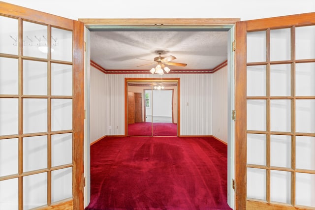 unfurnished room featuring carpet flooring, a textured ceiling, a ceiling fan, and ornamental molding