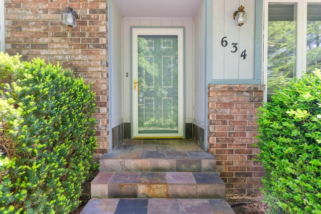 doorway to property with brick siding