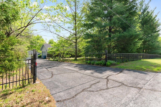 view of road with a gated entry and aphalt driveway