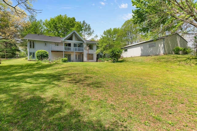 back of house with a balcony and a yard