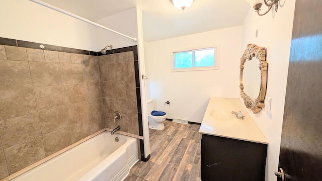 bathroom featuring vanity, visible vents, wood finished floors, bathing tub / shower combination, and toilet