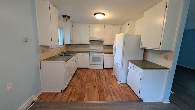 kitchen featuring wood finished floors, dark countertops, white appliances, under cabinet range hood, and a sink