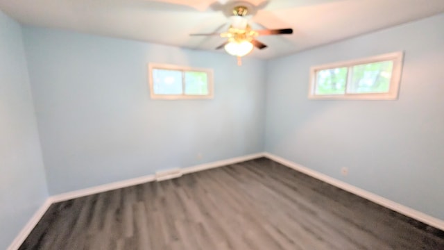 spare room with baseboards, ceiling fan, a healthy amount of sunlight, and wood finished floors