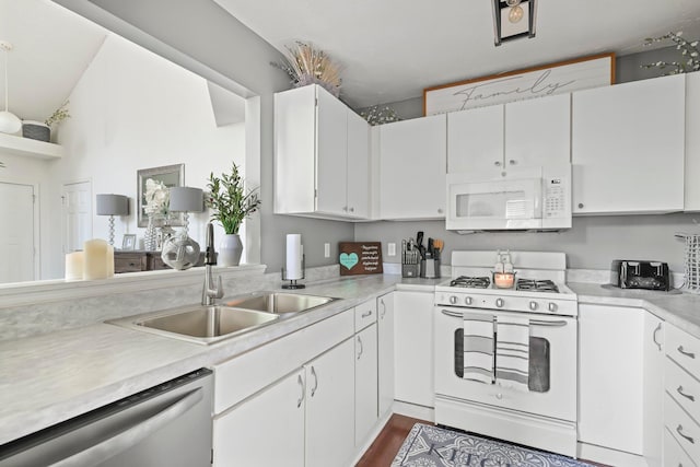 kitchen with white appliances, white cabinetry, a sink, and light countertops