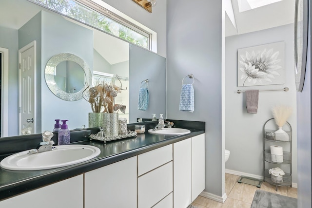 full bathroom with double vanity, a sink, tile patterned flooring, and toilet