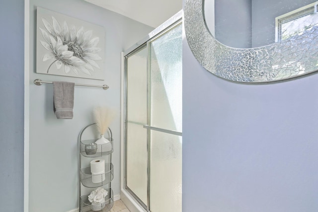 bathroom with baseboards and a stall shower