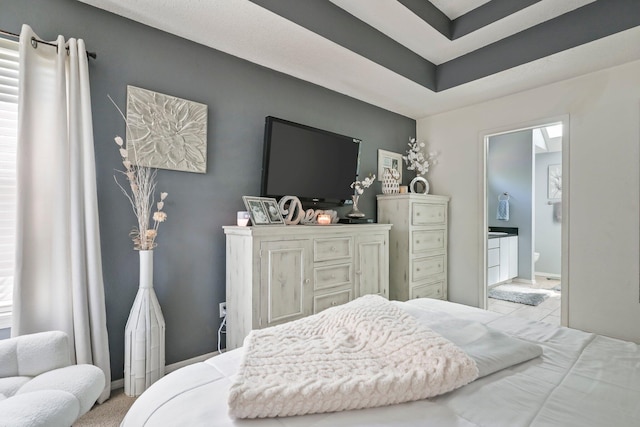 bedroom with ensuite bathroom and baseboards