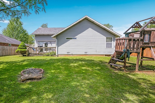back of house featuring a wooden deck, fence, a playground, crawl space, and a yard