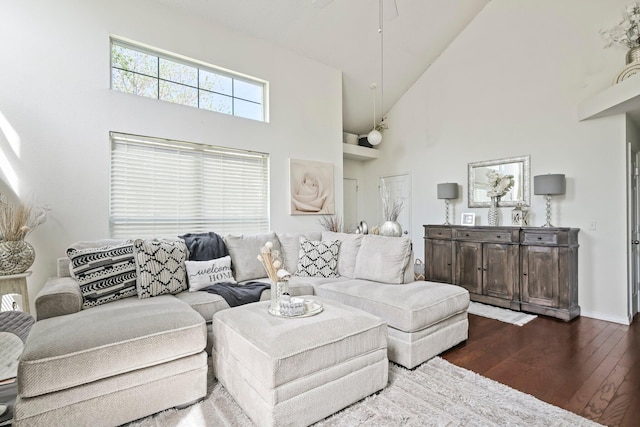 living room with a ceiling fan, high vaulted ceiling, dark wood-style floors, and baseboards