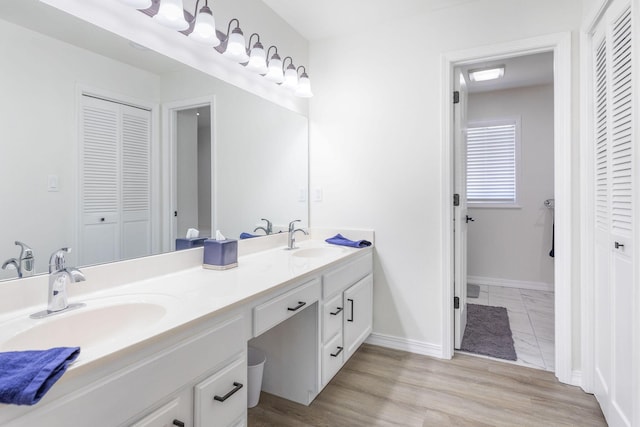 full bath featuring double vanity, a sink, and a closet