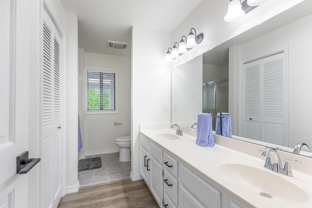full bath with a sink, a closet, toilet, and visible vents