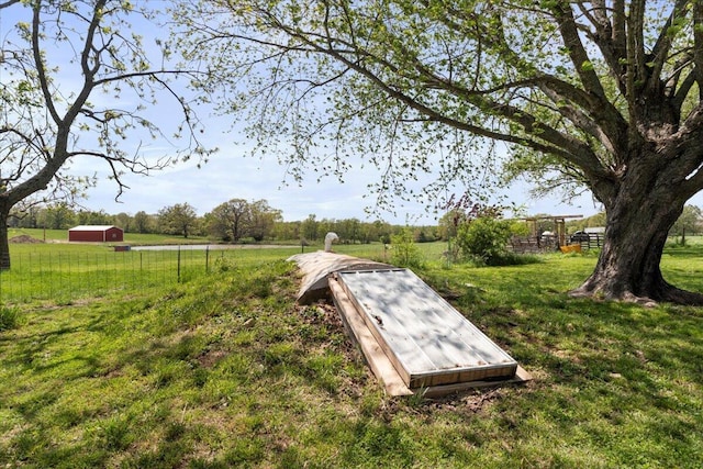 view of storm shelter featuring a lawn and a rural view