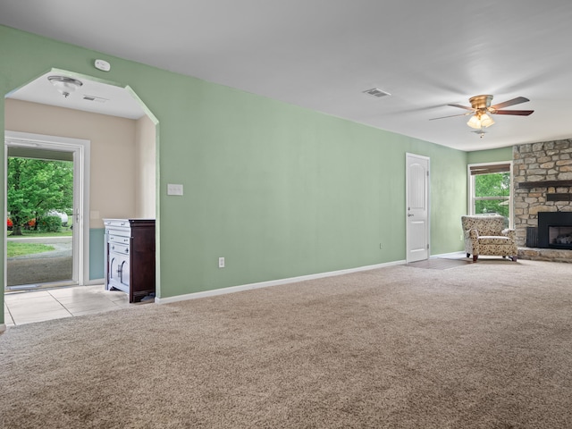 1208 Kemp Dr, Bolivar, MO 65613 - unfurnished living room featuring baseboards, ceiling fan, carpet, and a stone fireplace