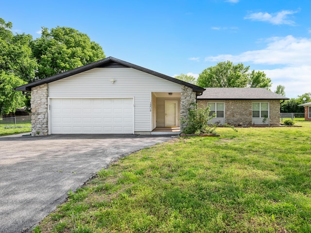 1208 Kemp Dr, Bolivar, MO 65613 - ranch-style house featuring driveway, a front yard, a garage, fence, and stone siding