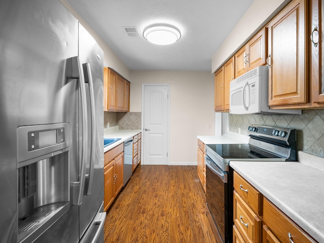1208 Kemp Dr, Bolivar, MO 65613 - kitchen featuring light countertops, brown cabinetry, stainless steel appliances, backsplash, and dark wood-style floors