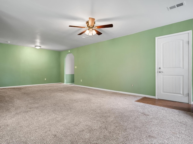 1208 Kemp Dr, Bolivar, MO 65613 - carpeted empty room with arched walkways, ceiling fan, visible vents, and baseboards