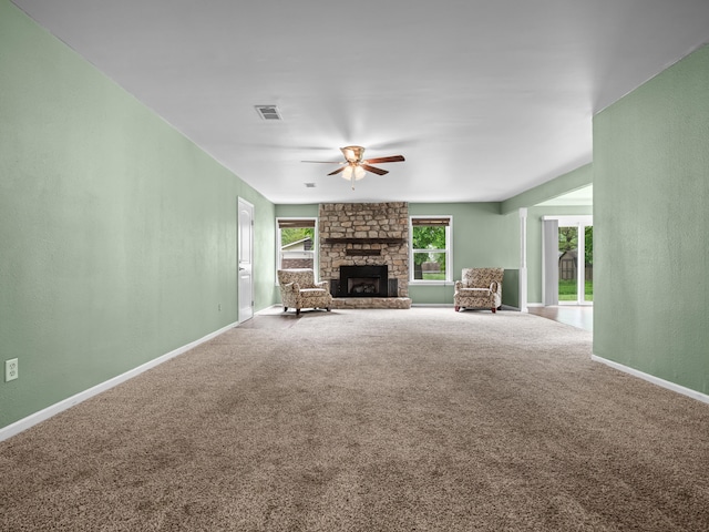 1208 Kemp Dr, Bolivar, MO 65613 - unfurnished living room with ceiling fan, a stone fireplace, visible vents, baseboards, and carpet