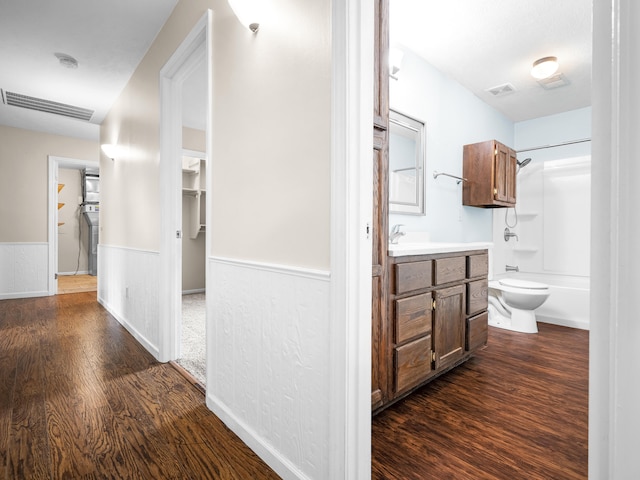 1208 Kemp Dr, Bolivar, MO 65613 - corridor featuring dark wood-style flooring, visible vents, and a wainscoted wall