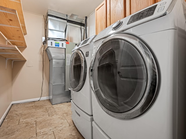 1208 Kemp Dr, Bolivar, MO 65613 - laundry room featuring baseboards, washing machine and dryer, stone finish flooring, and cabinet space