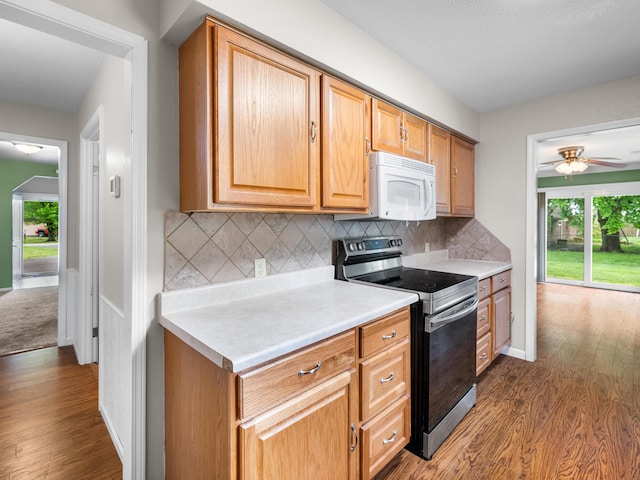 1208 Kemp Dr, Bolivar, MO 65613 - kitchen featuring plenty of natural light, white microwave, dark wood-style flooring, and stainless steel electric range