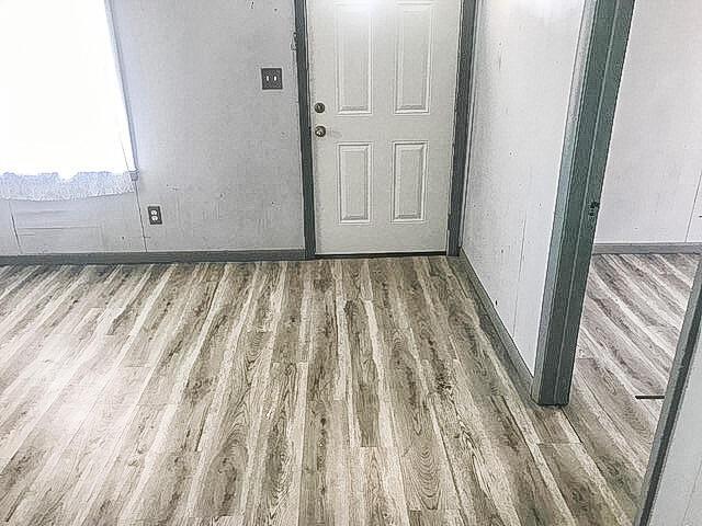 interior space featuring baseboards and wood finished floors
