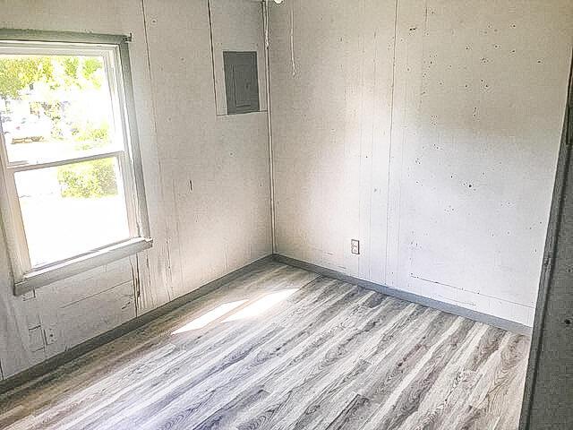 unfurnished room featuring wood finished floors and electric panel