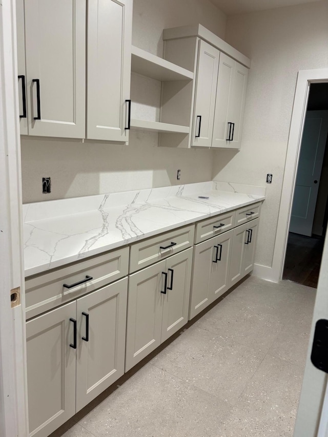 1971 N Alysheba Ct, Springfield, MO 65802 - kitchen featuring open shelves, light stone counters, and baseboards