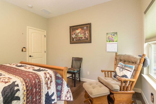 bedroom with baseboards, wood finished floors, and visible vents