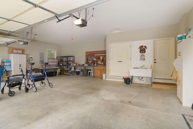 garage with a workshop area, a garage door opener, and electric panel