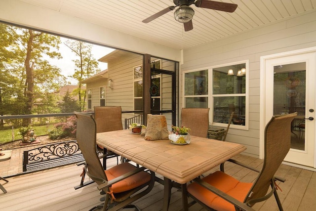 sunroom / solarium with outdoor dining space and ceiling fan