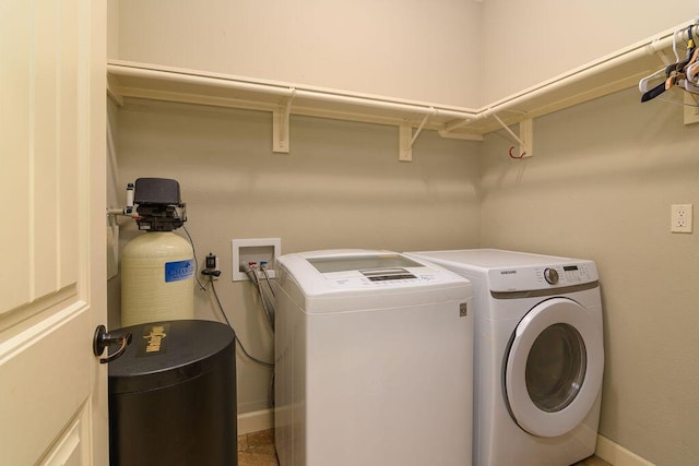 clothes washing area featuring washer and dryer, laundry area, and baseboards