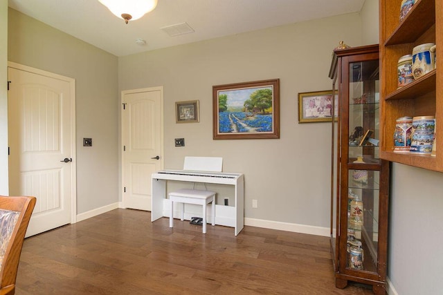 interior space with baseboards, dark wood finished floors, and visible vents
