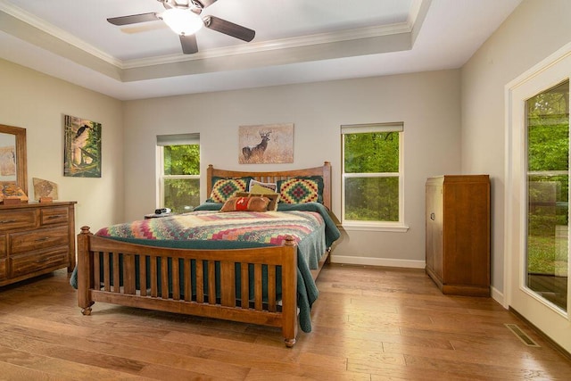 bedroom with visible vents, a raised ceiling, and crown molding