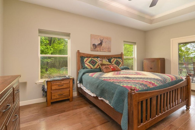 bedroom featuring baseboards, ornamental molding, a ceiling fan, and wood finished floors