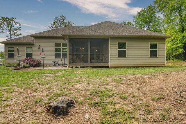 back of house with a yard, a sunroom, and a patio area