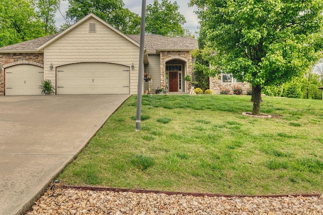 view of front facade with a shingled roof, an attached garage, stone siding, a front yard, and concrete driveway
