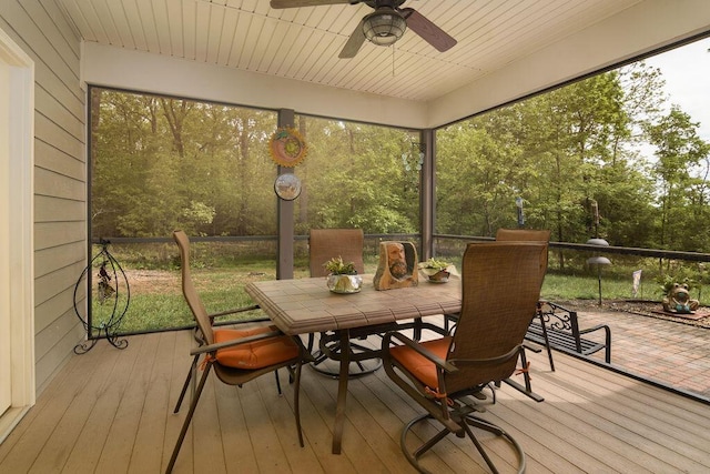 sunroom / solarium with plenty of natural light, outdoor dining area, and ceiling fan