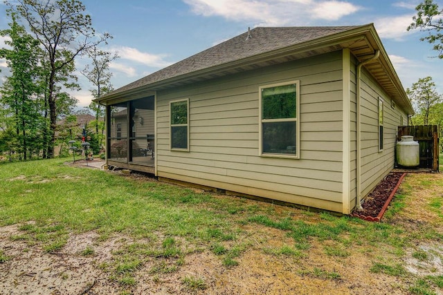 view of property exterior with a lawn and a shingled roof