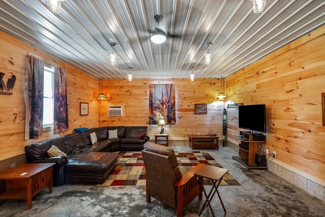 living area with wood walls, a wall unit AC, and unfinished concrete floors