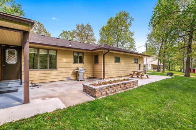 back of house with a lawn and a patio