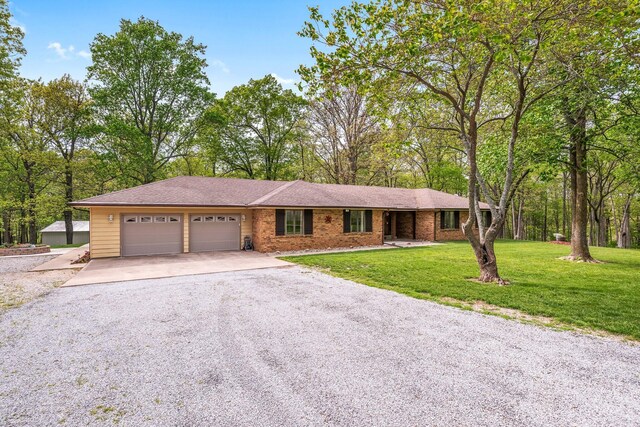 ranch-style home featuring an attached garage, driveway, and a front yard