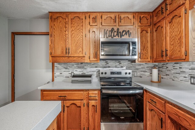 kitchen with light countertops, a textured ceiling, backsplash, and stainless steel appliances