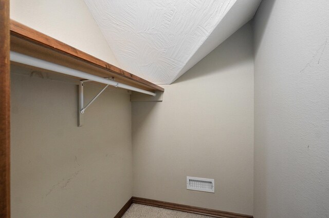 walk in closet with visible vents and vaulted ceiling