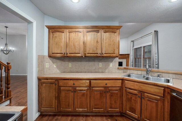 kitchen with a sink, light countertops, stainless steel appliances, decorative backsplash, and dark wood-type flooring