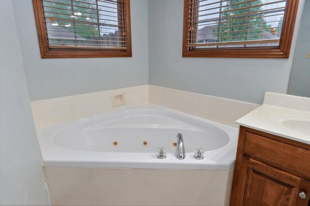 bathroom with a jetted tub and vanity